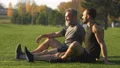 The happy son and a father sitting on the grass and talking 4k or 4k+ Resolution