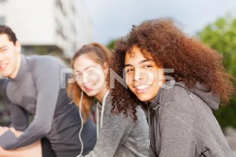 Happy sportswoman exercising outdoors with friends Stock Photos