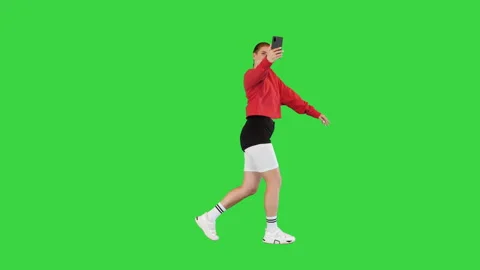 Happy street dancer walks dancing slightly and taking a selfie on a Green Screen Stock Footage 219468985