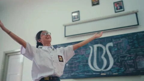 Happy Student Dancing and Pointing in a Classroom Stock Footage 235620612