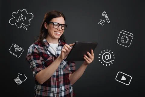 Happy student holding a tablet while chatting online Stock Photos