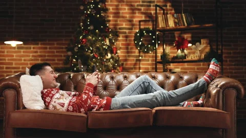 Happy student jumping on couch in decorated apartment in evening after work Stock Footage 194590151