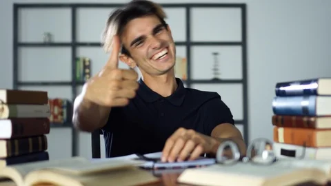 Happy student posing with thumbs up and looking at you, Books, Education Concept Stock Footage 93280390