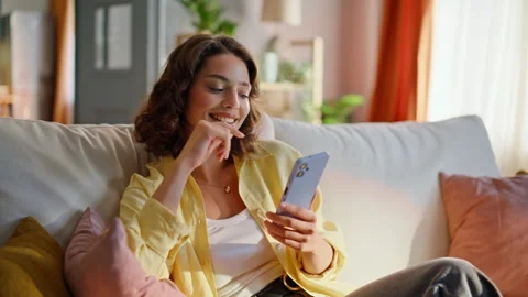 Happy student reading message mobile phone relaxing on cozy home couch closeup. Stock Footage 333315886