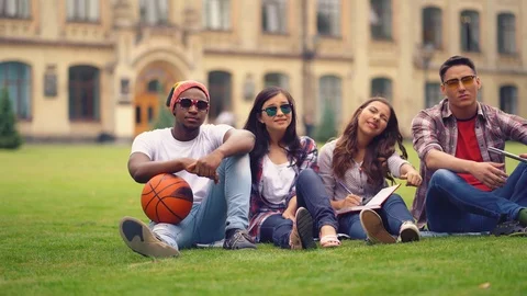 Happy student spend time together sitting on grass near university Video stock 126283535