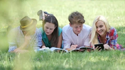 Happy Students Are Reading Lying on a Grass Students Girls and Boys Are 動画素材 64812777