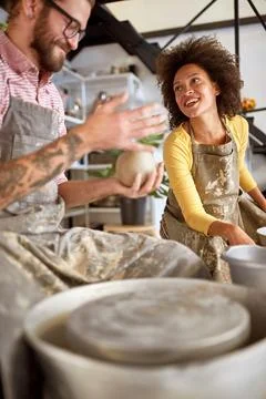 Happy students having fun shaping clay pots at pottery workshop.  Creative,.. Stock Photos
