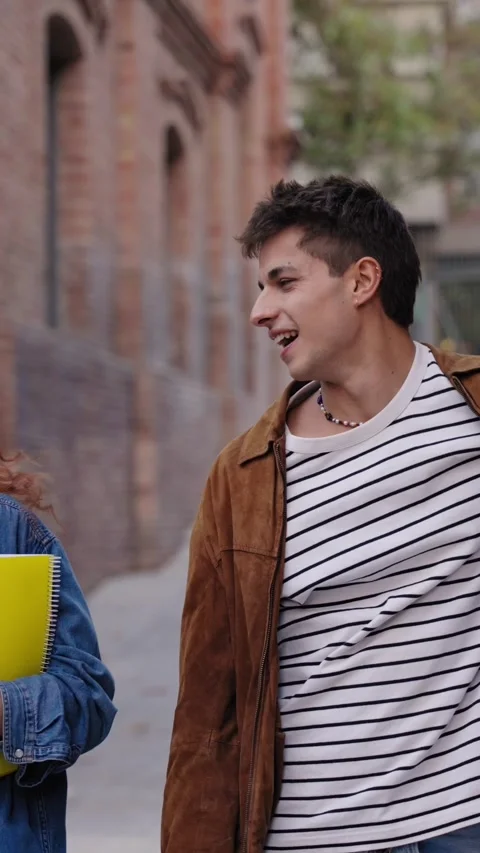 Happy students strolling around the university campus with workbooks and Stock Footage 273630068