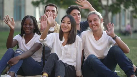 Happy students waving hello while posing outdoors Stock-Footage 163280337
