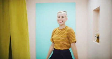 Happy, stylish girl with pixie cut trying on outfit in dressing room in interior Stock Footage 199455989