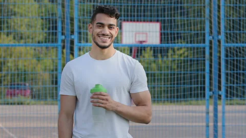 Happy successful middle eastern indian man athlete latino runner holding sports Stock Footage 161913769