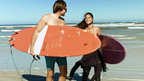 Happy surfing couple returning to shore Video stock 76521165