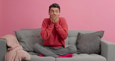 Happy surprised man keeps hands on cheeks and reacts at something awesome Stock Footage 143624986