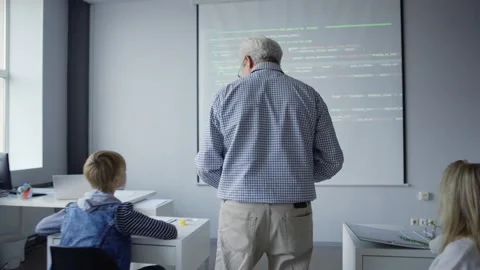 Happy teacher explaining computer science to children Stock Footage 142492769