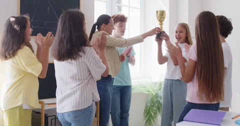 Happy teacher giving school trophy prize award, pleased competition, study Stock Footage 313341885