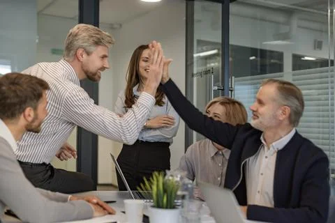 Happy teamwork give high five. Successful business meeting in nice creative l Stock Photos