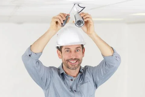 Happy technician installing cctv camera for security Stock Photos