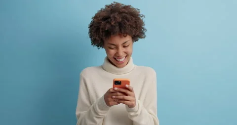 Happy technology mobile user holds mobile phone sends text messages looks Stock Footage 143630259