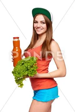 Happy teen girl holding a bottle of carrot juice Stock Photos