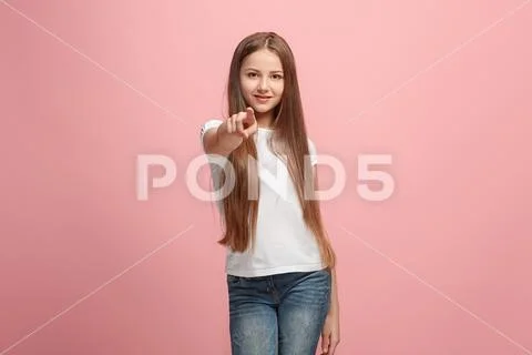 The happy teen girl pointing to you, half length closeup portrait on pink Stock Photos
