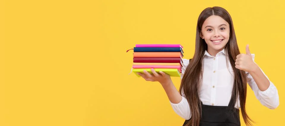 Happy teen girl in school uniform hold book stack show thumb up gesture Stock Photos