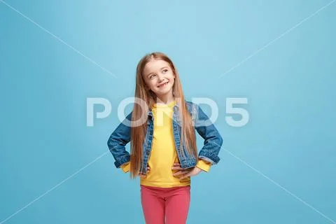 The happy teen girl standing and smiling against pink background. Stock Photos