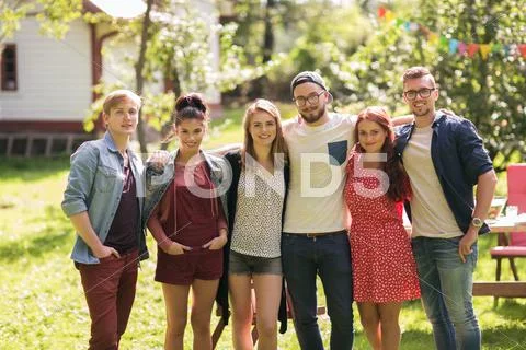 Happy teenage friends hugging at summer garden Stock Photos