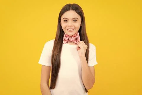 Happy teenager portrait of smiling girl child in t-shirt with bowtie isolated on Stock Photos