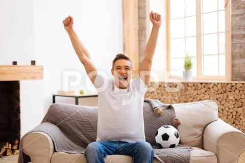 Happy teenager watching football at home Stock Photos