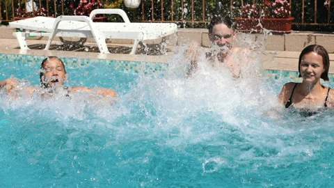 Happy teens having fun in a pool splashing water Stock Footage 179478221