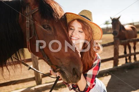 Happy tender young woman cowgirl hugging her horse Stock Photos