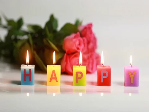 Happy text candle flame, with roses in background Stock Footage 73011196