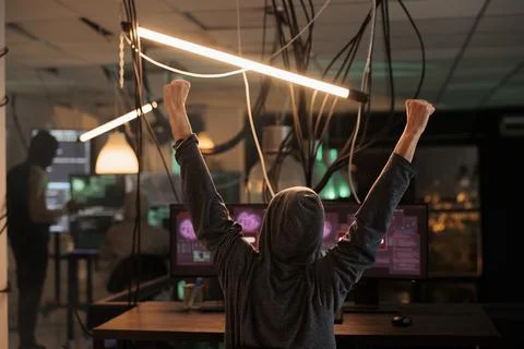 Happy thief celebrating security breach and hacking computer system Stock Photos