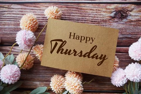 Happy Thursday text message with flower decoration on wooden background Stock Photos