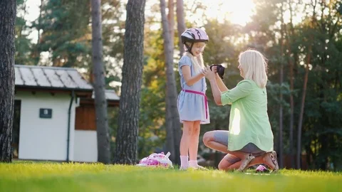 Happy time together. Mom puts on protective mittens to daughter, they prepare to Stock Footage 80021447
