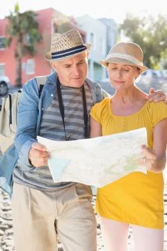 Happy tourist couple using map in the city Fotos Stock