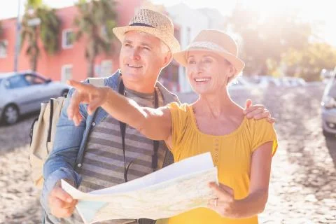 Happy tourist couple using map in the city Fotos Stock