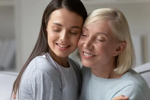 Happy two generations cuddling hugging in living room. Stock Photos