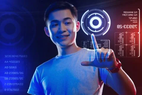 Happy web developer touching a round hologram on the screen and smiling 库存照片