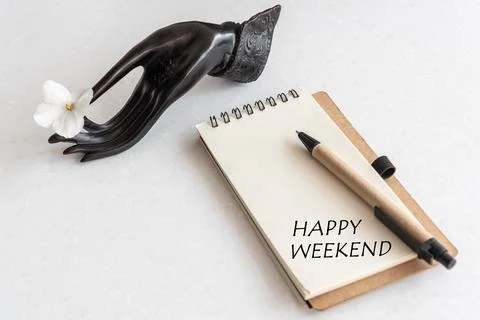 Happy Weekend Word in open notebook and flower in black hand. Office Workplace Stock Photos