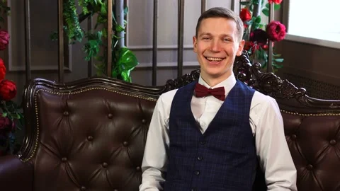 Happy white man looking to camera while sitting on couch at cosy stylish room. Stock Footage 152852126