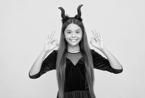 Happy witch devil kid show ok gesture wear imp horns costume on halloween party Stock Photos