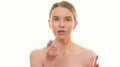 The happy woman is applying lipstick on her lips on the white background 4k or 4k+ Resolution