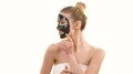 The happy woman with a black face care mask flirts on the white background 4k or 4k+ Resolution