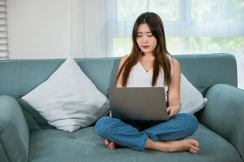 Happy woman browsing through the internet during free time on laptop computer Stock Photos