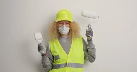 Happy woman builder has fun dances with painting tools holds brush and roller Stock Footage 155490047