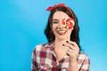The happy woman with a candy gesturing on the blue background Photo