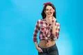 The happy woman with a candy standing on the blue background Photo