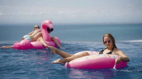Happy woman chill in infinity pool with inflatable donut rubber ring Stock Footage 269120946