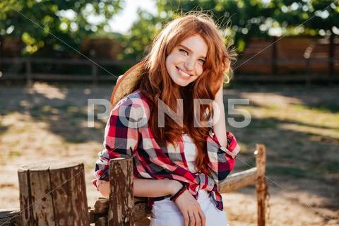 Happy woman cowgirl standing and smiling on farm Stock Photos